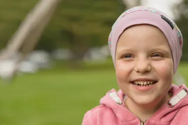 Ein lächelndes Kind mit einer dünnen Mütze